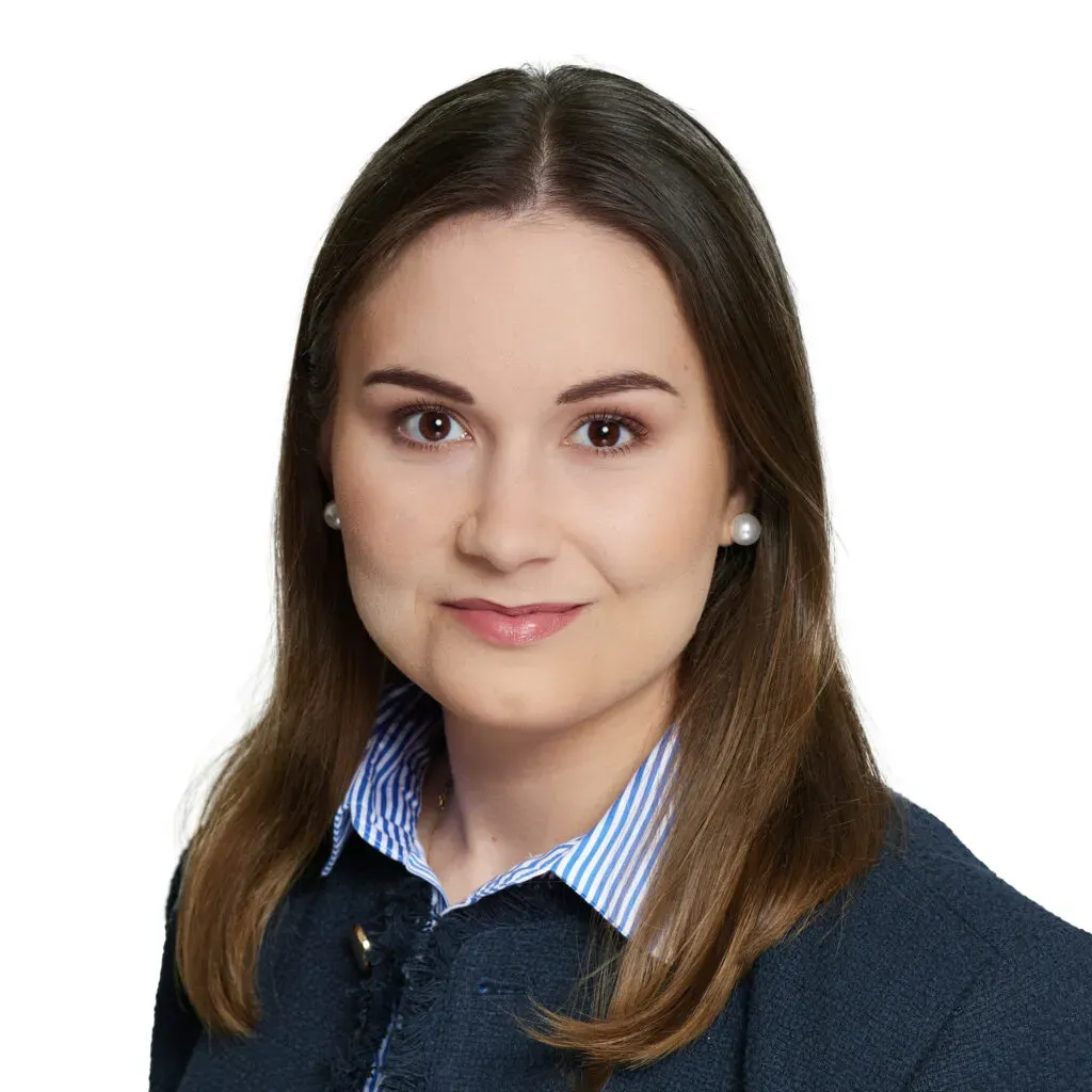 Aplikantka radcowska kancelarii KRK z prostymi brązowymi włosami, w granatowym żakiecie i koszuli w biało-niebieskie paski – zdjęcie biznesowe do sekcji Zespół