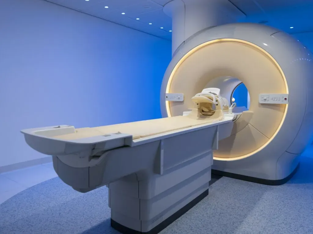 Nowoczesny tomograf komputerowy w szpitalnym pomieszczeniu o niebieskim oświetleniu – ilustracja do sekcji wyroby medyczne w kancelarii KRK